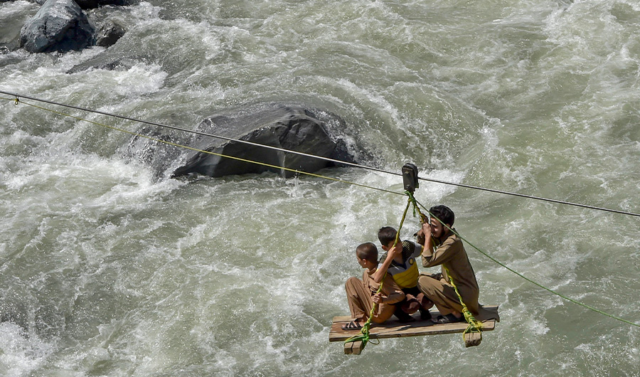 Local residents use a temporary cradle service to cross the river Swat after heavy rains in Bahrain town of Swat valley in Khyber Pakhtunkhwa province on August 31, 2022. (AFP)