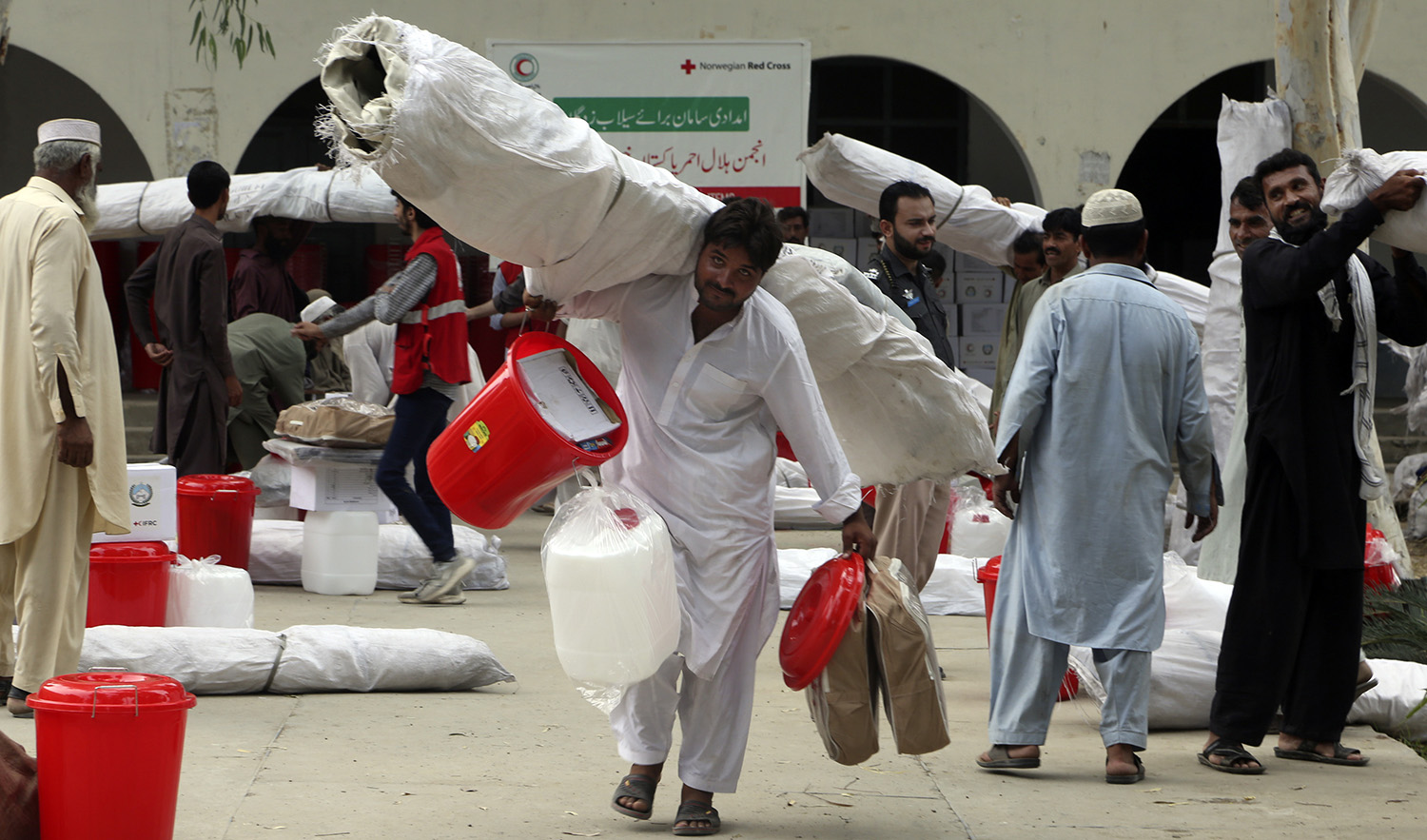 Victims of unprecedented flooding from monsoon rains receive relief aid in Charsadda, Pakistan, on September 5, 2022. (AP)