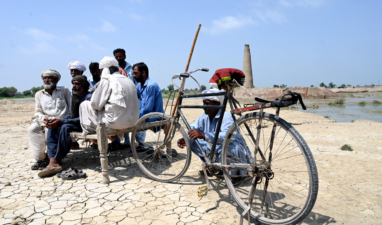 In this picture taken on September 4, 2022, Muhammad Ayub (2L) sits with other labourers near their brick kiln damaged by floodwaters following heavy monsoon rains in Aqilpur area in Rajanpur district of Punjab province. (AFP)