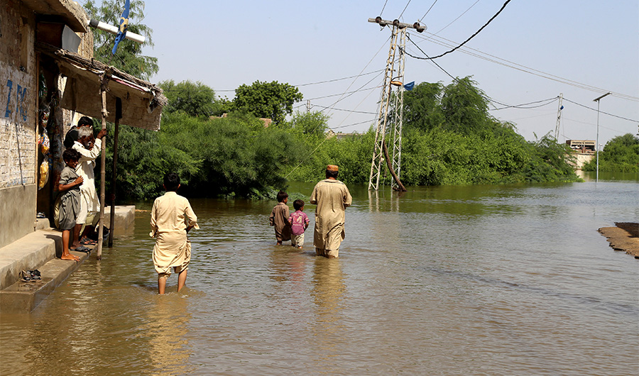 Internally displaced flood-affected people gather outside a shop in a flood-hit area following heavy monsoon rains in Jamshoro, a town of Hyderabad in Sindh province on September 6, 2022. (AFP)