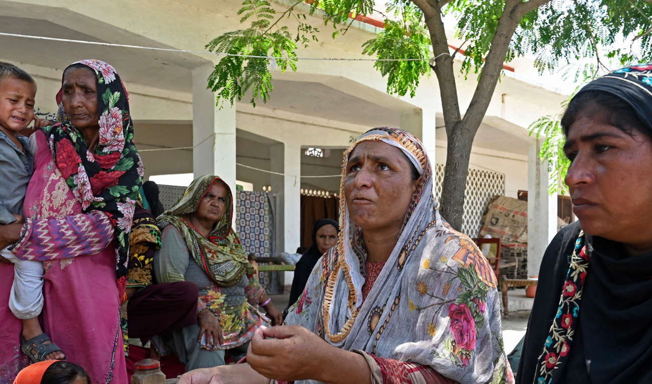 In this picture taken on September 3, 2022, Zebunnisa Bibi (C), a flood-affected woman speaks during an interview with AFP to explain her toilet issues at a makeshift camp in Fazilpur, Rajanpur district of Punjab province. (AFP)