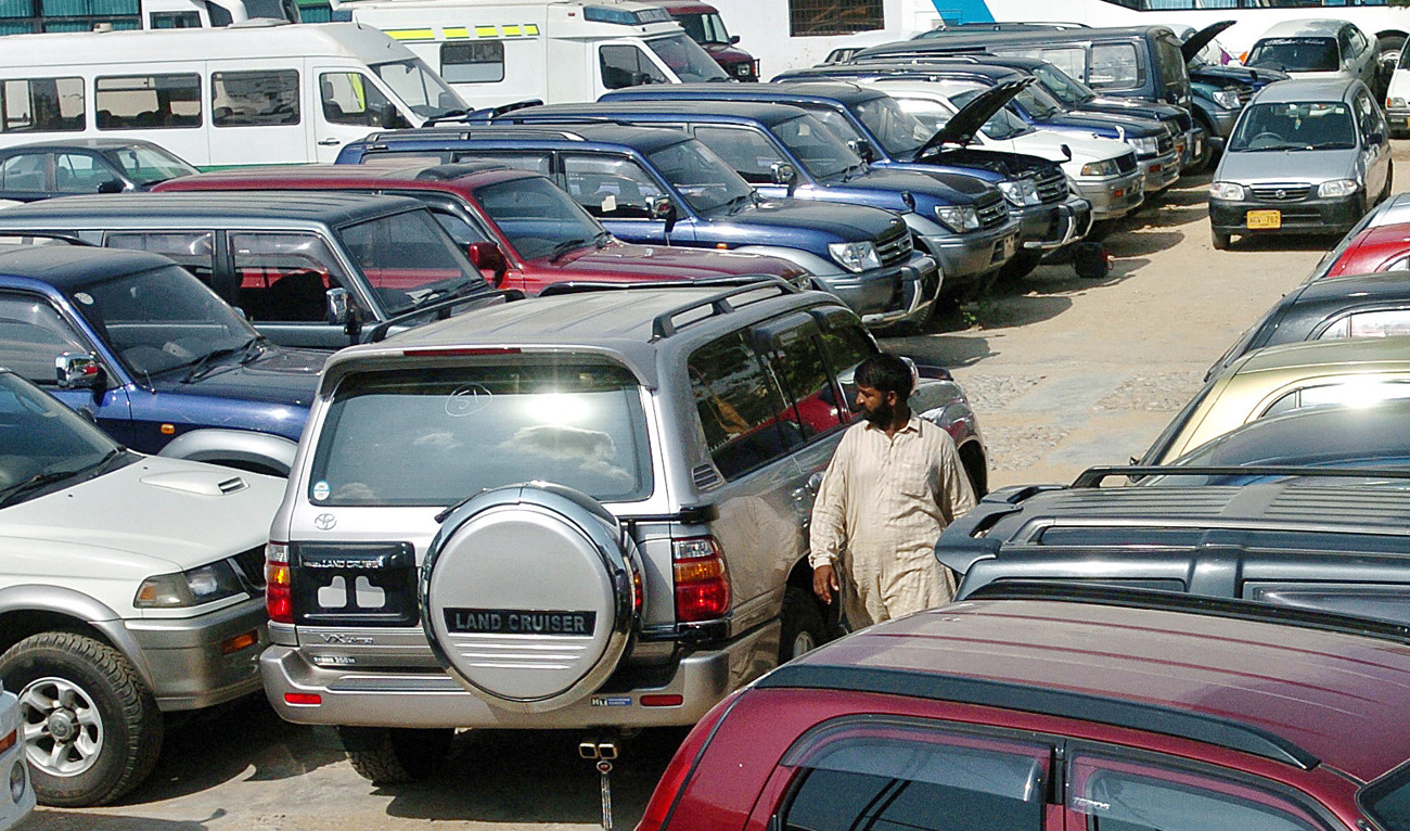A Pakistani employee of a car showroom walks amidst new cars displayed at an auto dealer center in Karachi, 12 October 2006. (AFP/File)