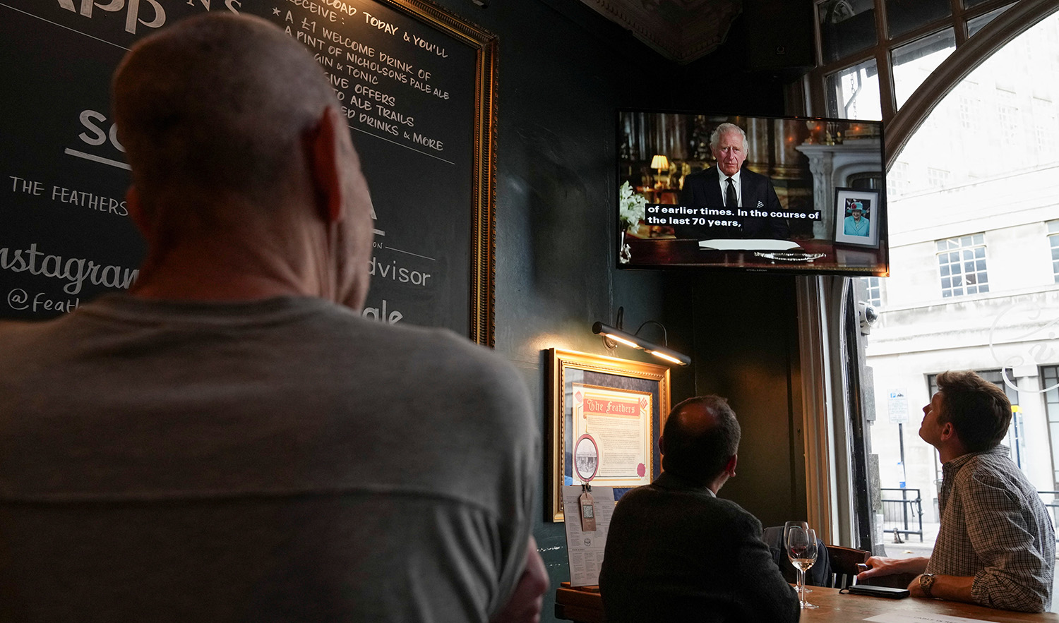 People watch Britain's King Charles address the nation in a televised speech following the passing of Britain's Queen Elizabeth, at The Feathers pub, in London, Britain, September 9, 2022. (REUTERS)