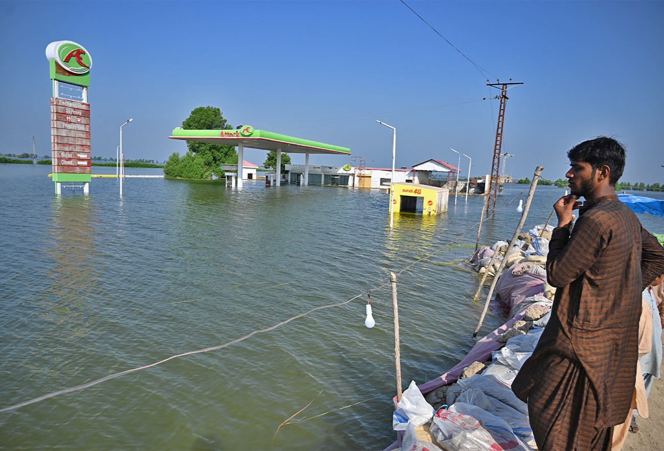 Flood-affected people gather by an embankment in Mehar city after heavy monsoon rains in Dadu district, Sindh province on September 9, 2022. (AFP)