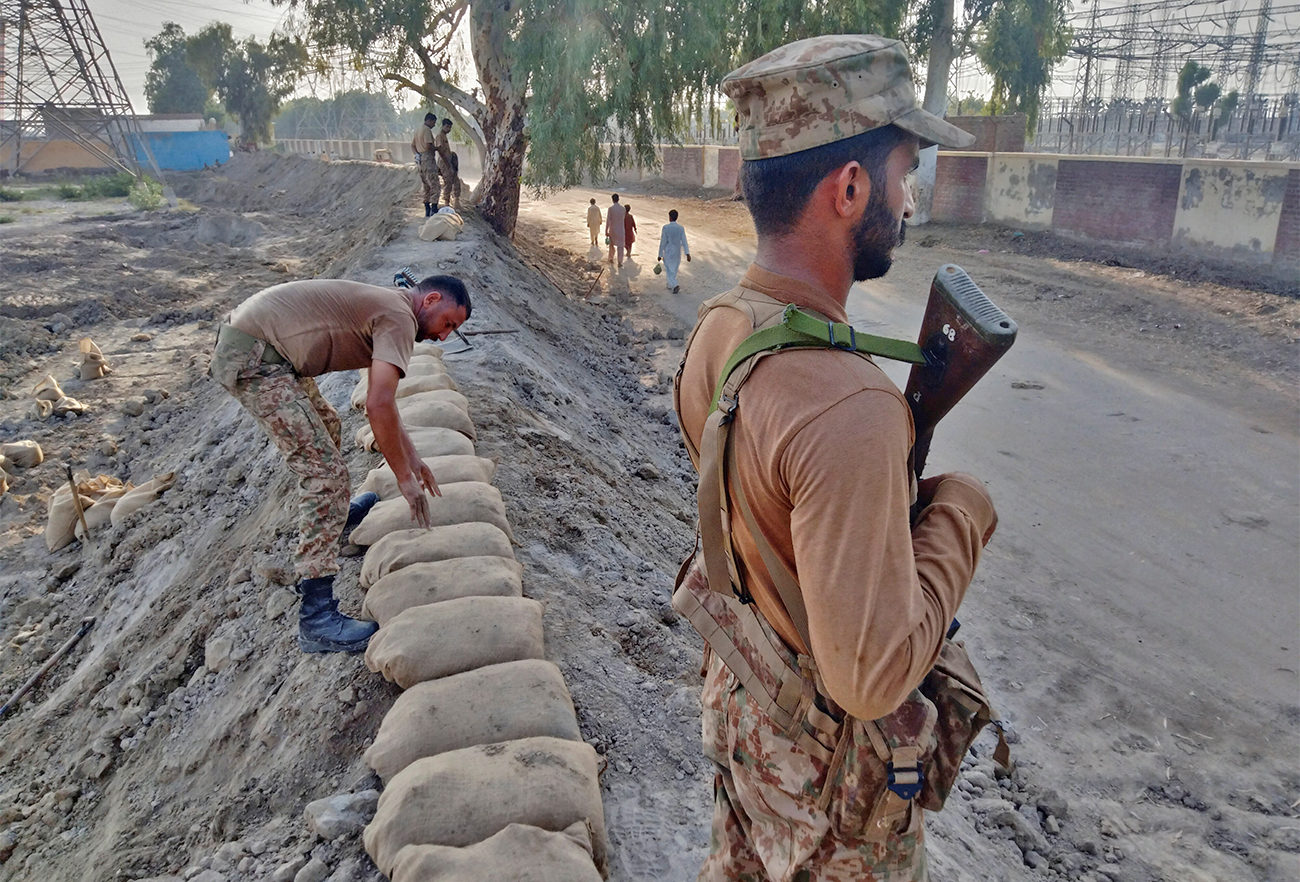 Members of Pakistan's Army guard and look after a dike to protect a power station, following rains and floods during the monsoon season, in Dadu, Pakistan on September 11, 2022. (REUTERS)