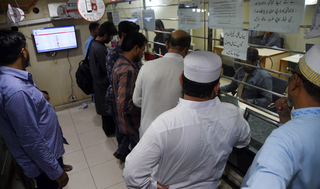 In this picture taken on July 22, 2019, customers exchange foreign currency at a money changer in Karachi. (AFP/File)