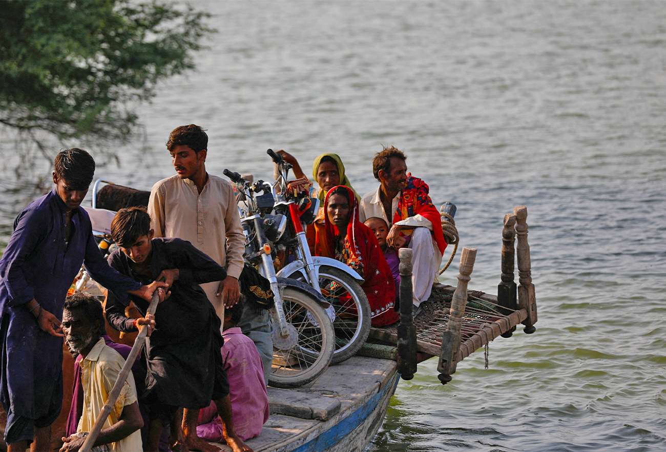 A flood victim family with their belongings, travels in a boat as they head to their village, following rains and floods during the monsoon season in Sehwan, Pakistan on September 14, 2022. (REUTERS)