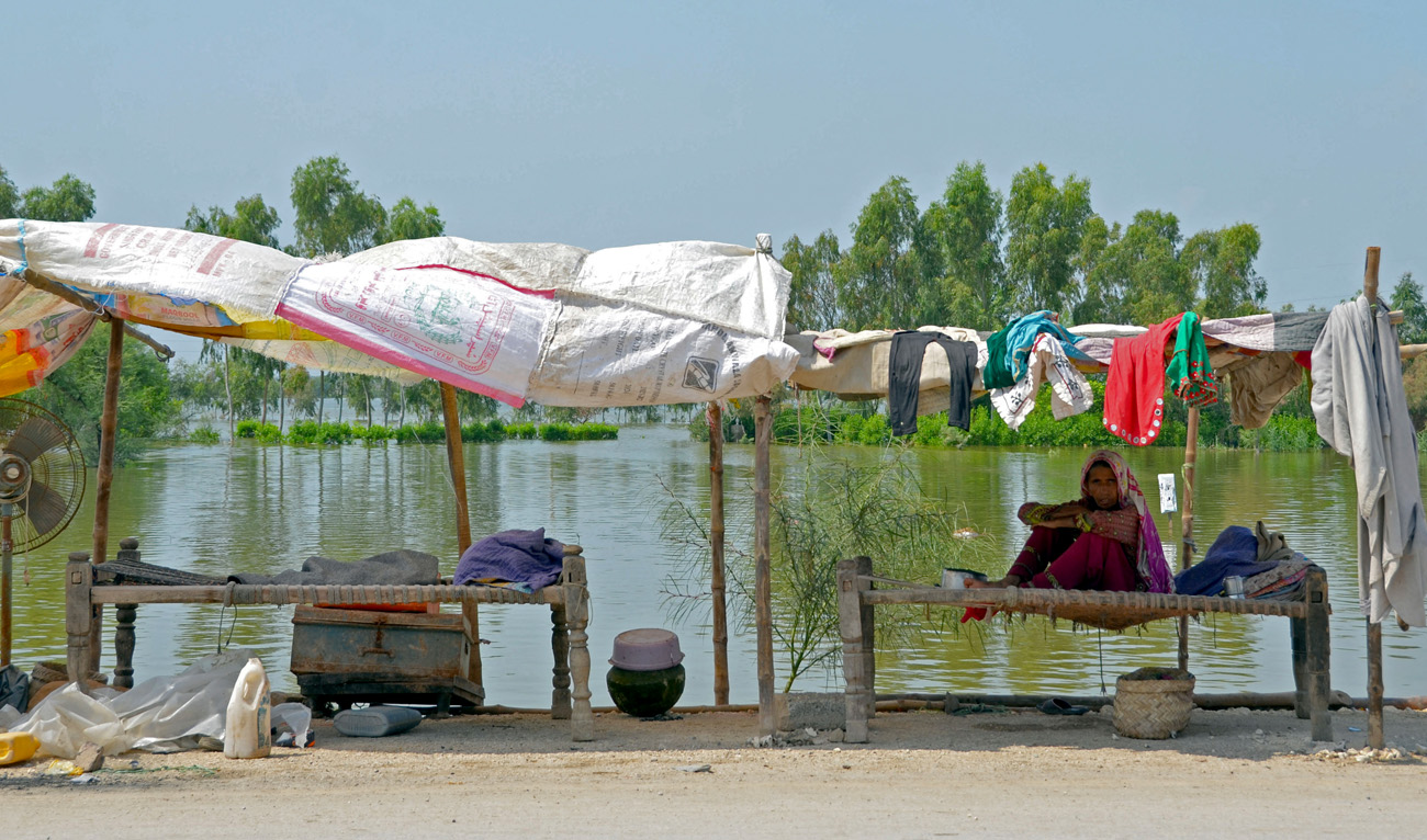 An internally displaced flood-affected woman sits at her makeshift shelter in a flood-hit area following heavy rains in Dera Allah Yar town of Jaffarabad district in Balochistan province on September 8, 2022. (AFP)