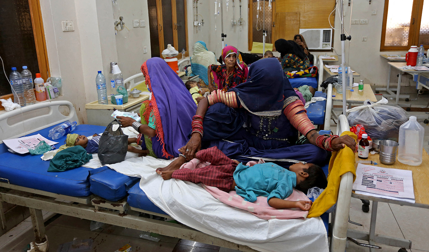 Internally displaced people take care of their children under treatment for malaria and gastro in the flood-hit Hyderabad city of Pakistan's Sindh province on September 11, 2022. (AFP)
