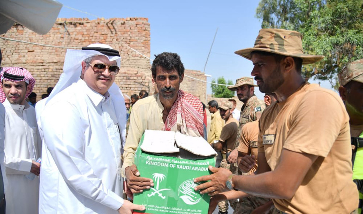 Saudi Arabia's Ambassador to Pakistan Nawaf bin Said Al-Malki, left, distributes relief items among residents of the flood-hit areas of the South Asian country on September 16, 2022. (Photo courtesy: KSA Embassy in Islamabad)