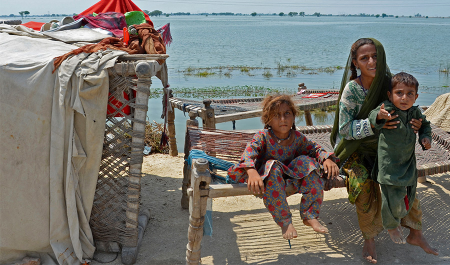 An internally displaced flood-affected family sits outside their makeshift shelter in a flood-hit area following heavy rains in Dera Allah Yar town of Jaffarabad district in Balochistan province on September 8, 2022. (AFP)