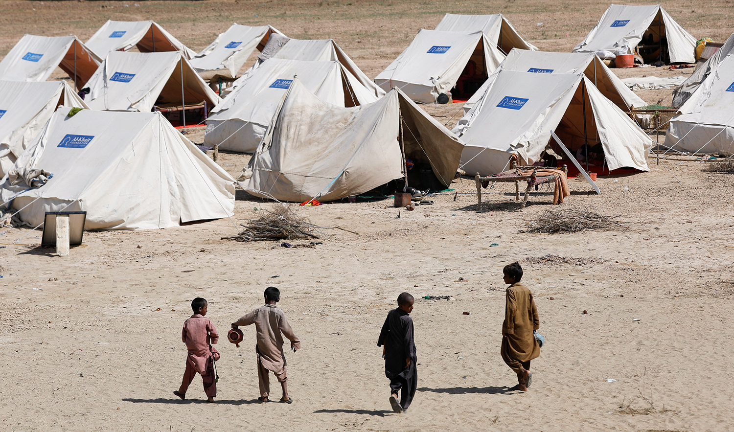 Displaced children walk outside their family tents in a camp, following rains and floods during the monsoon season in Sehwan, Pakistan, on September 16, 2022. (REUTERS)
