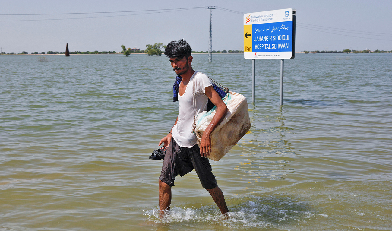 A displaced man walks on flooded highway, following rains and floods during the monsoon season in Sehwan, Pakistan, on September 16, 2022. (REUTERS)