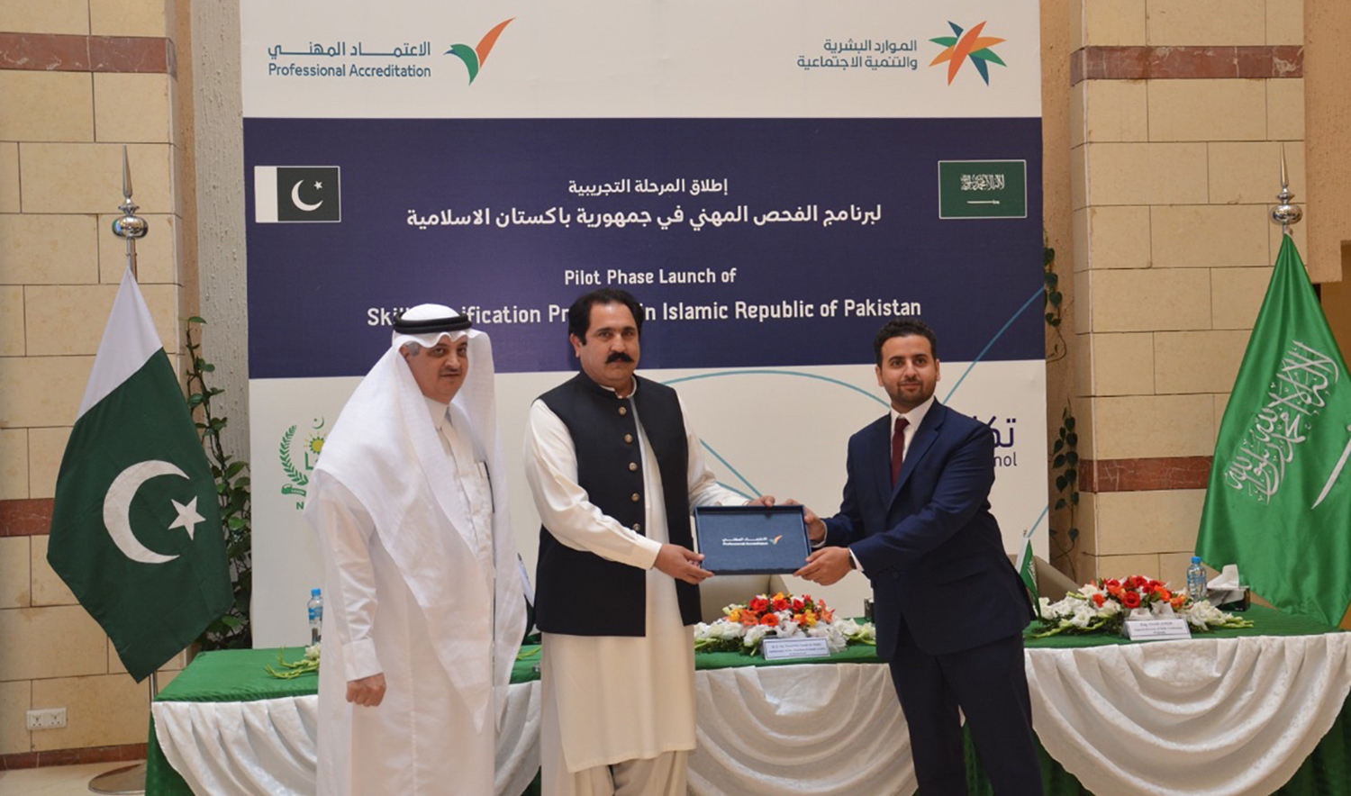 Director general of skill verification program, Saad Aiaqil, left, is exchanging program document with Pakistani minister for overseas Pakistanis Sajid Hussain Turk, center, in Islamabad on September 19, 2022. (Photo courtesy: Saudi Embassy Islamabad)