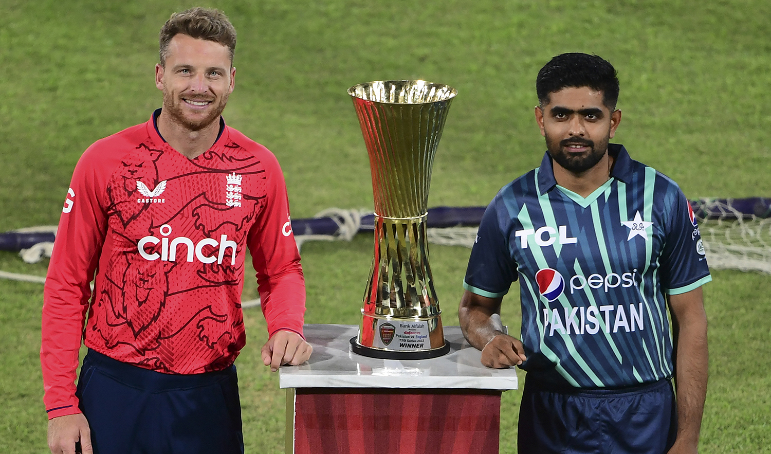Pakistan's captain Babar Azam, right, and his England's counterpart Jos Buttler pose with the Twenty20 series trophy on the eve of their first Twenty20 international cricket match at the National Cricket Stadium in Karachi on September 19, 2022. (AFP)