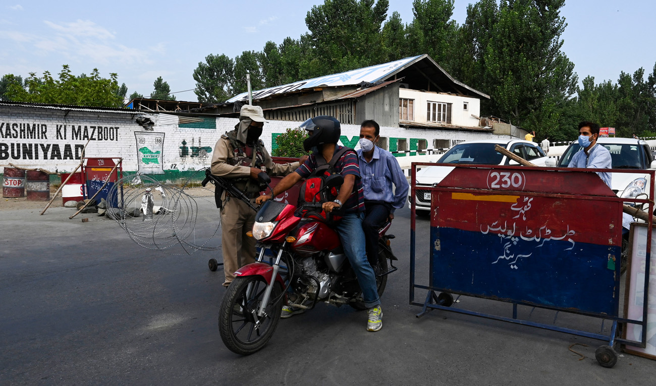 A paramilitary soldier questions a motorist at a checkpoint during a curfew in Srinagar on August 4, 2020, marking the first anniversary of New Delhi's abolition of the restive region's semi-autonomy. (AFP/File)