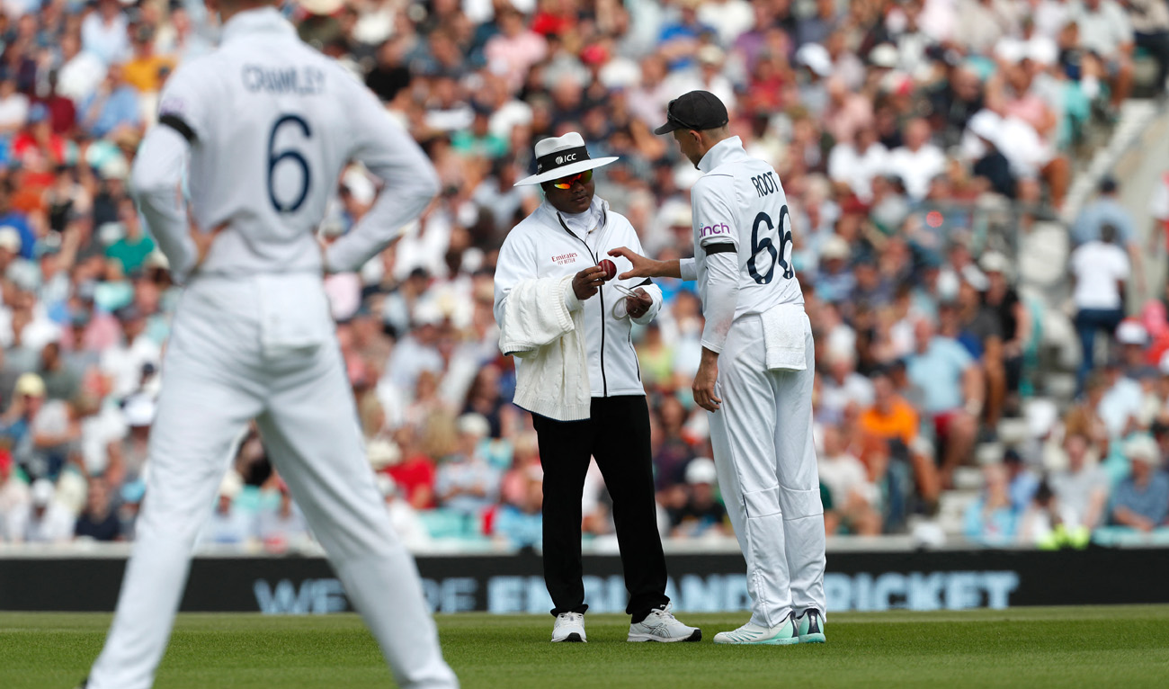 England's Joe Root (R) and India's umpire Nitin Menon (C) examine the state of the ball during play on the fourth day of the third Test cricket match between England and South Africa at The Oval, in London, on September 11, 2022. (AFP)