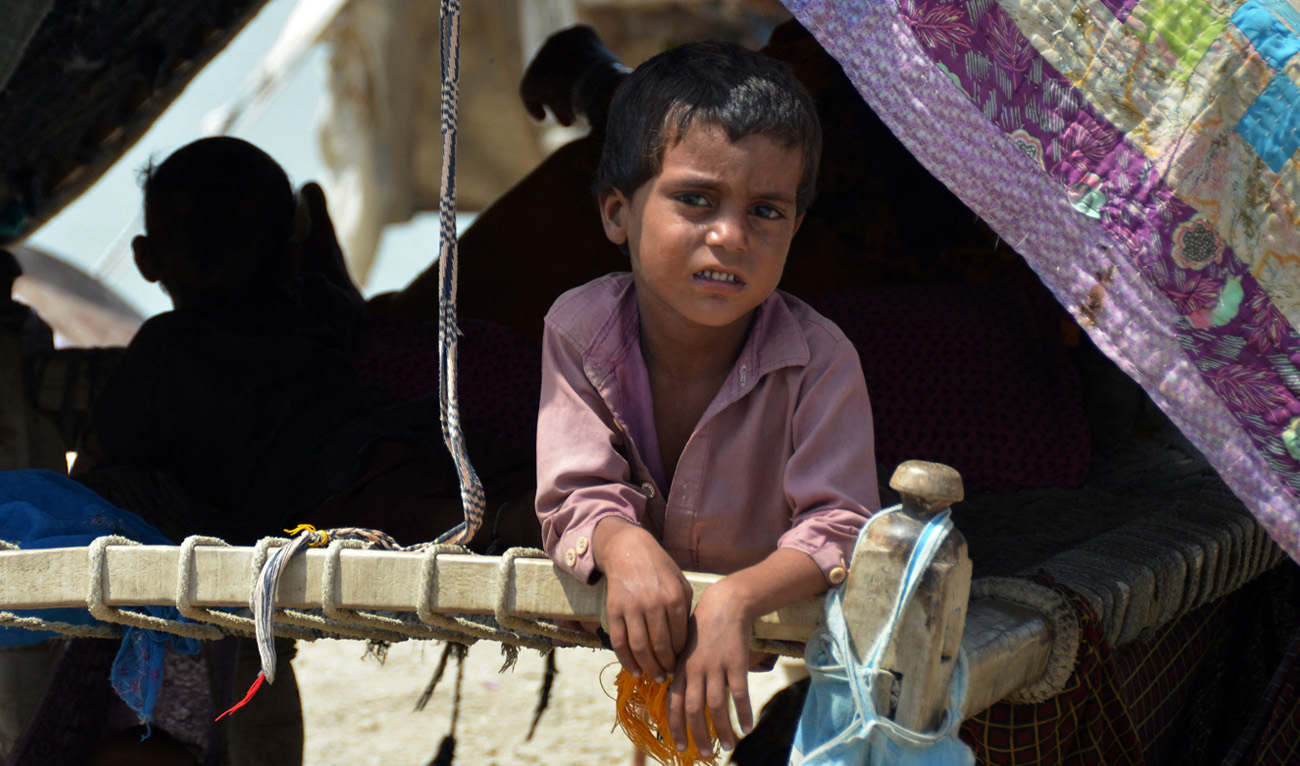 An Internally displaced flood-affected boy looks out from a makeshift tent at Dera Allah Yar town in Jaffarabad district, Balochistan province, on September 6, 2022. (AFP)