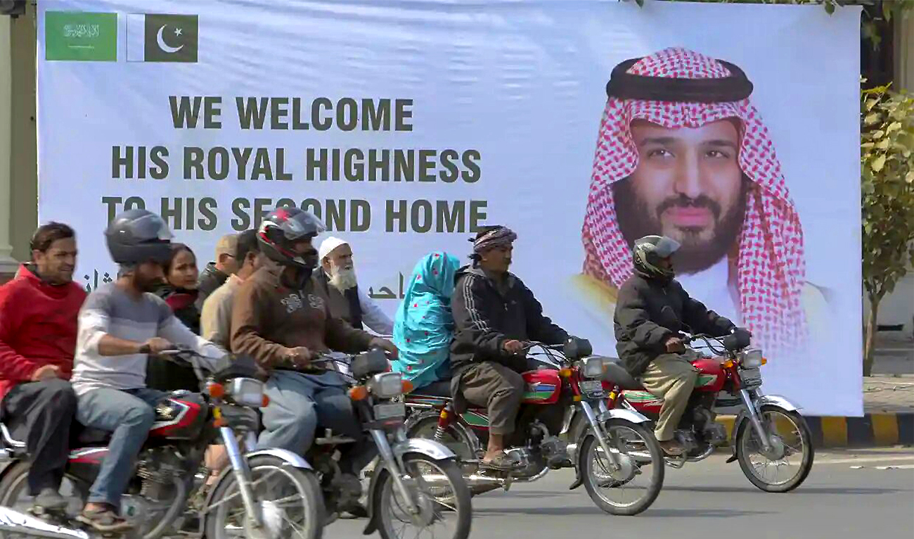 Motorcyclists ride past a billboard displaying a portrait of Saudi Crown Prince Mohammed bin Salman, ahead of the prince's arrival, in Islamabad, Pakistan, on February 16, 2019. (AP/File)