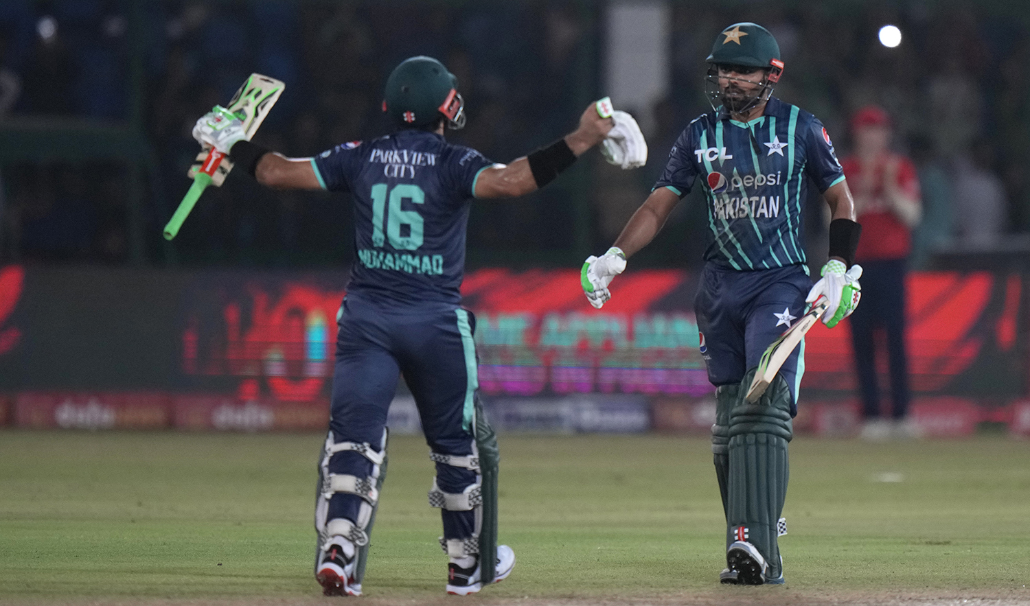 Pakistan's captain Babar Azam, right, celebrates with batting partner Mohammad Rizwan after scoring a century during the second T20 cricket match between Pakistan and England, in Karachi, Pakistan, on September 22, 2022. (AP)
