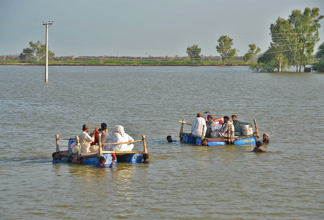 Internally displaced people wade through floodwaters after heavy monsoon rains at Usta Mohammad city in Jaffarabad district of Balochistan province on September 18, 2022. (AFP)