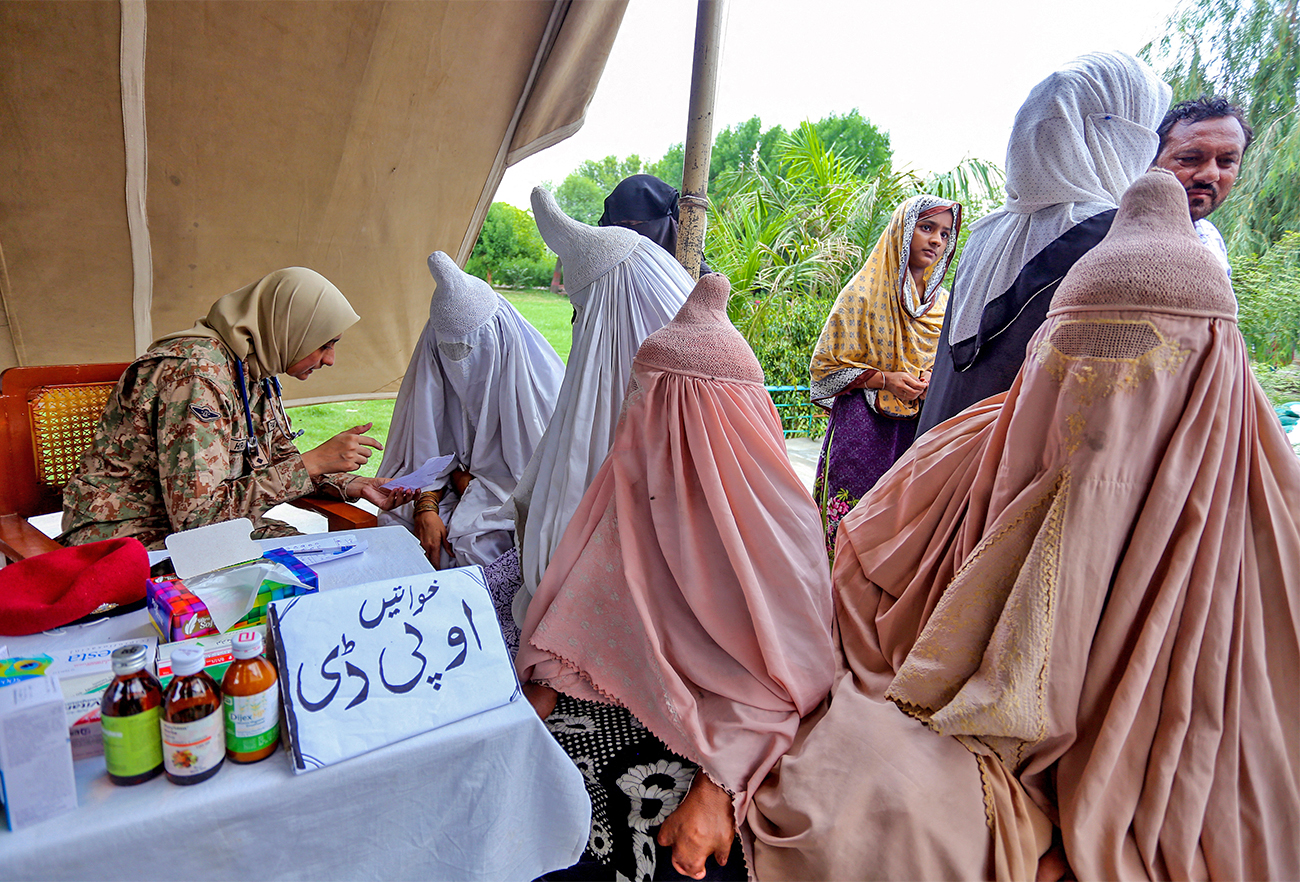An army doctor checks a woman at a makeshift hospital in the flood affected Rajanpur district, in Pakistan's Punjab province of Pakistan, on August 2, 2022. (AFP)