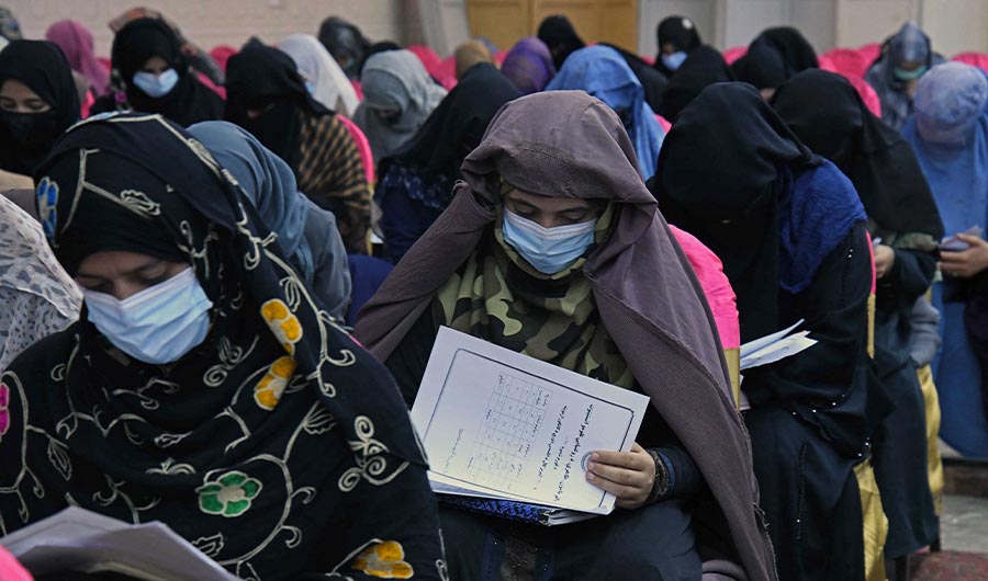 Afghan burqa-clad women take an entrance test at Mamon Tahiri institute in Kandahar on September 15, 2022. (AFP)