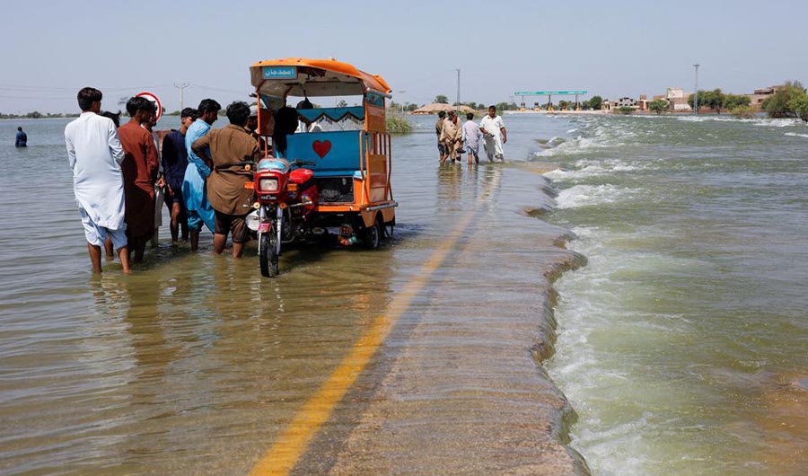 Displaced people stand on flooded highway, following rains and floods during the monsoon season in Sehwan, Pakistan, September 16, 2022. (REUTERS)