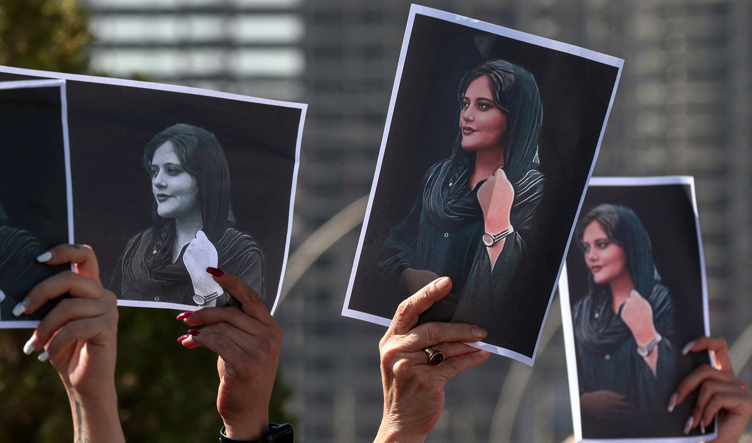 Women hold up signs depicting the image of 22-year-old Mahsa Amini, who died while in the custody of Iranian authorities, during a demonstration denouncing her death outside the UN offices in Arbil on September 24, 2022. (AFP)