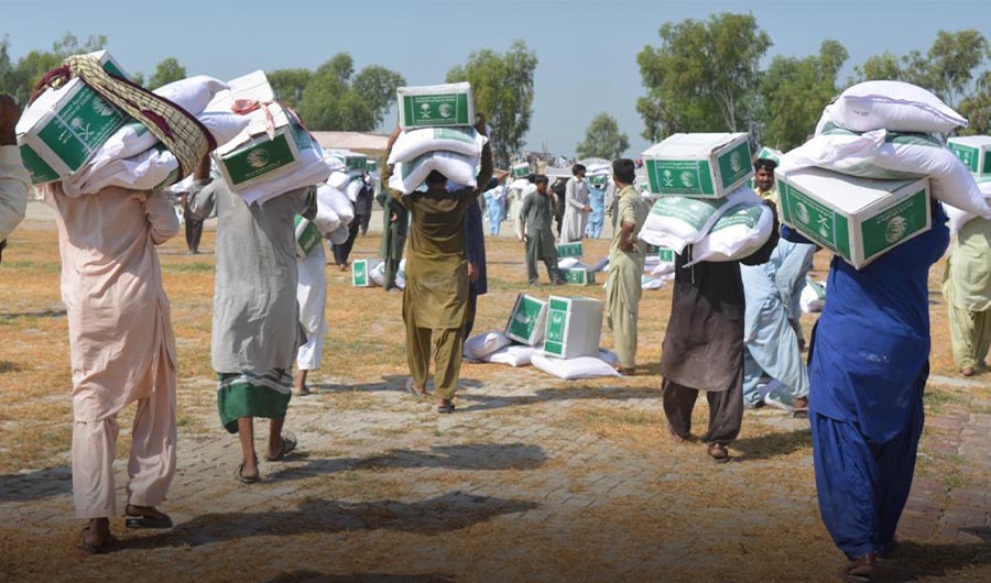 People carrying aid distributed by King Salman Humanitarian Aid and Relief Center (KSrelief) in flood-affected areas of Pakistan on Sep 24, 2022.(SPA)