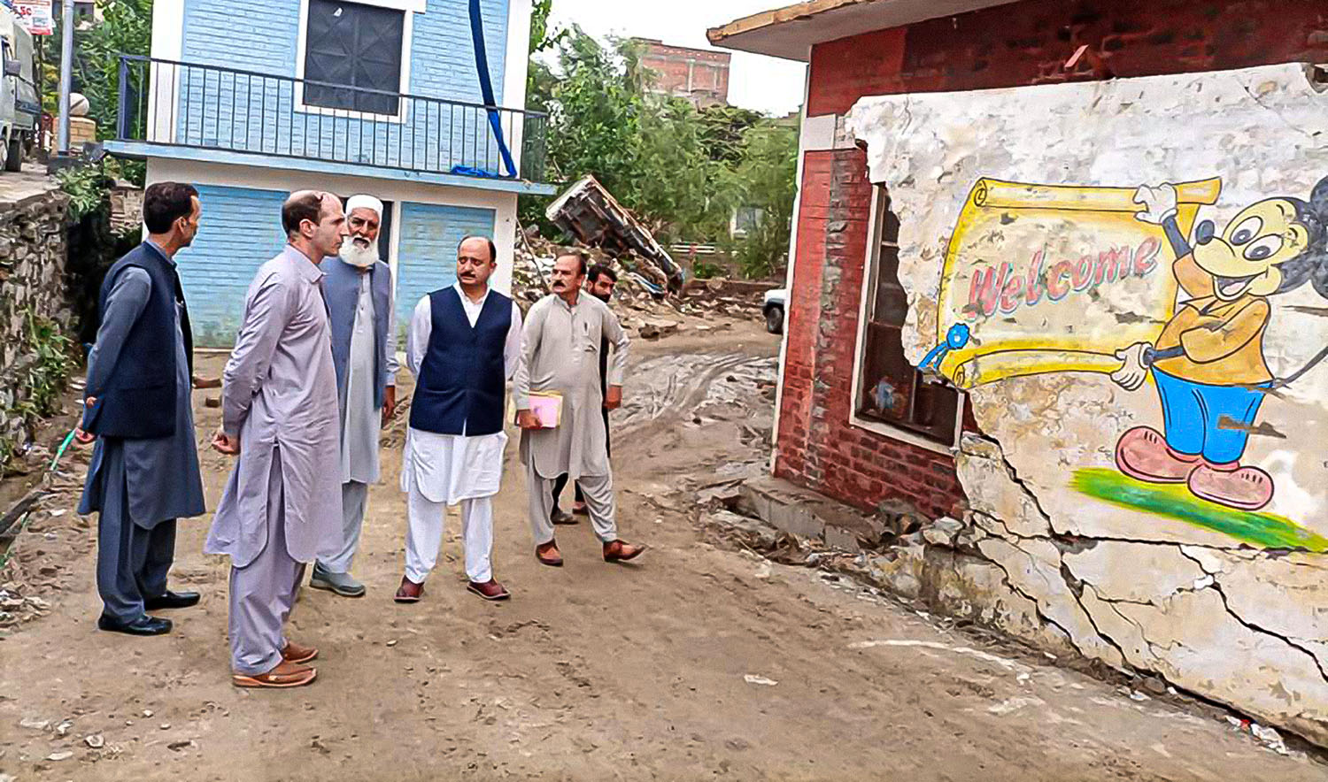 In this undated photo, officials inspect a school damaged by recent floods in Swat, Pakistan. (KP Elementary and Secondary Education Department)