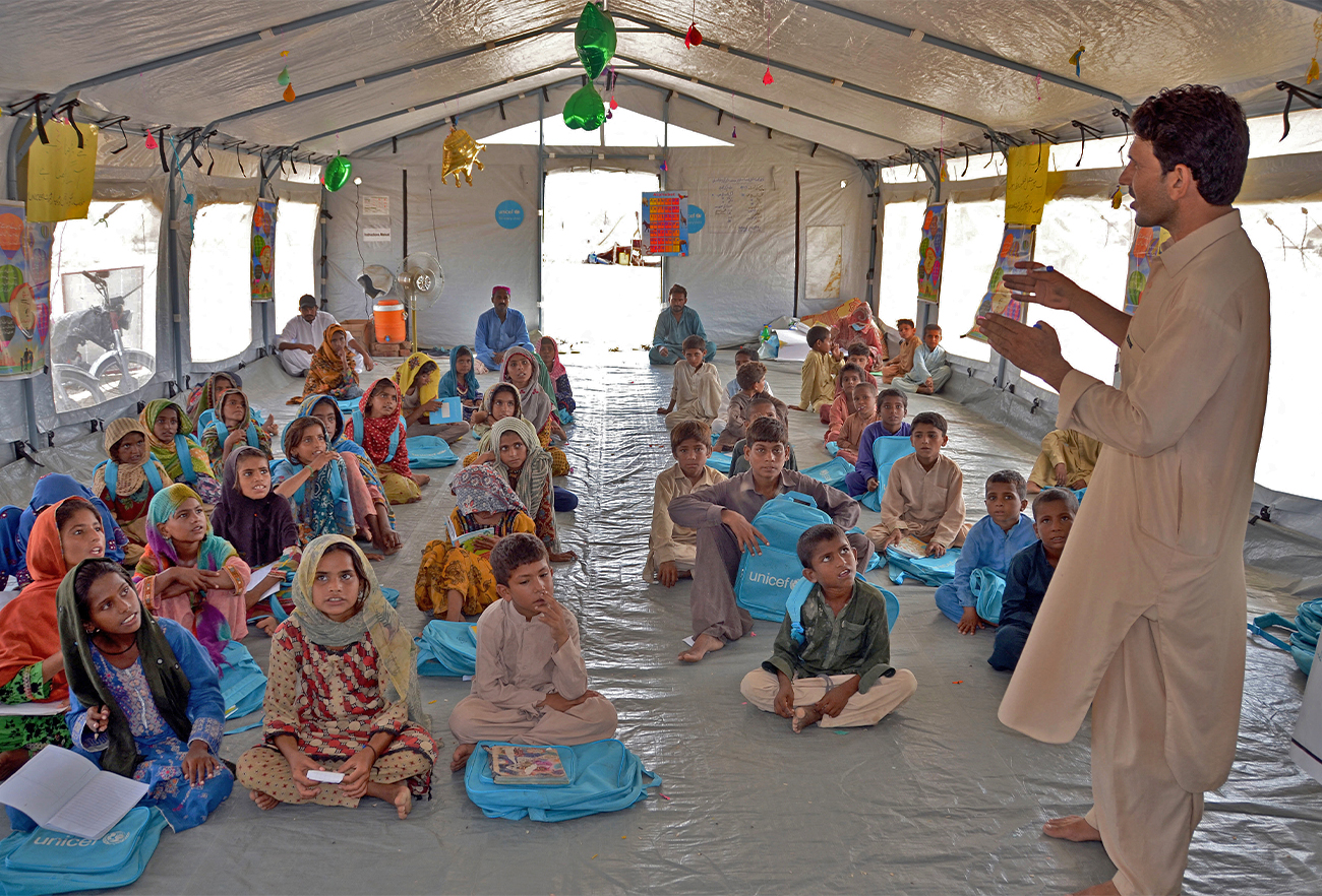 Internally displaced flood-affected children attend a class at a makeshift school at Dera Allah Yar in Jaffarabad district of Balochistan province in Pakistan on September 21, 2022. (AFP)