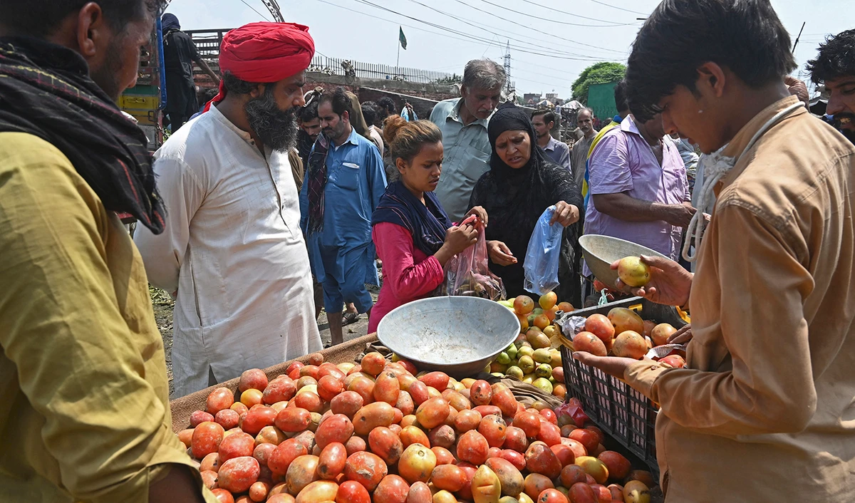 People buy fruits at a local market in Lahore, Pakistan, on August 30, 2022. (AFP)