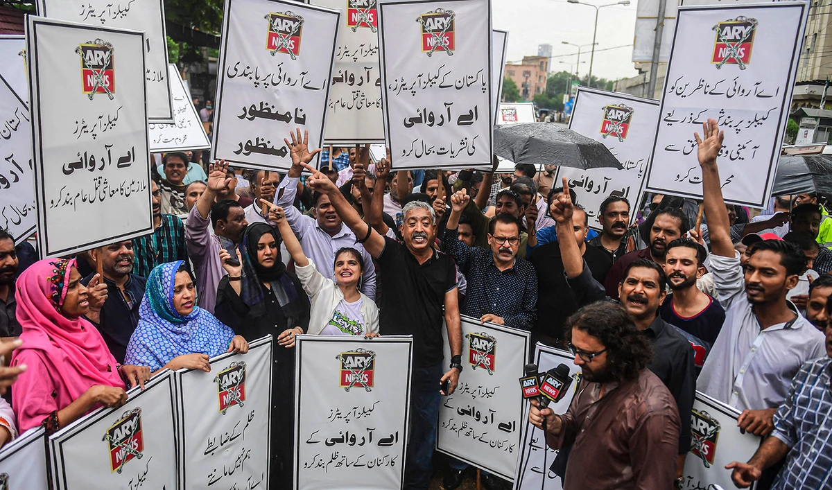 Journalists and employees of ARY News carry placards as they chant slogans during a protest against the channel being taken off air by the government in Karachi, Pakistan, on August 16, 2022. (AFP/File)