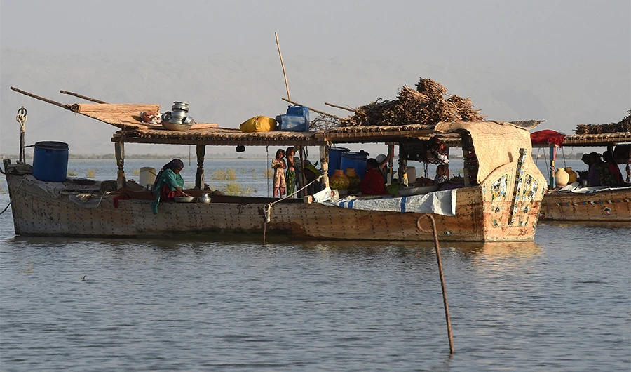 In this photograph taken on September 9, 2016, women do the household chores on their floating boathouse on Manchar lake in southern Pakistan. (AFP/FILE)