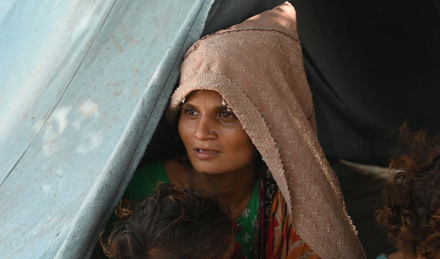 Saira Bibi, a pregnant flood-affected woman sits with her children at her tent in a makeshift camp along a railway track in Fazilpur, Rajanpur district of Punjab province on September 3, 2022. (AFP)
