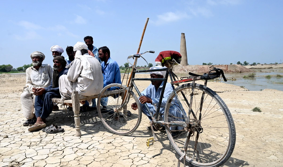 In this picture taken on September 4, 2022, Muhammad Ayub (2L) sits with other labourers near their brick kiln damaged by floodwaters following heavy monsoon rains in Aqilpur area in Rajanpur district of Punjab province. (AFP)