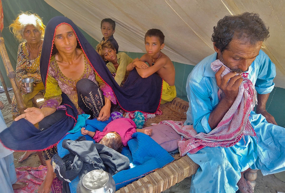 Badar Bibi, 29, a flood victim who's ailing 6-year-old son died at the relief camp she and her family were taking refuge at, sits in the camp following rains and floods during the monsoon season in Sehwan, Pakistan on September 9, 2022. (REUTERS)