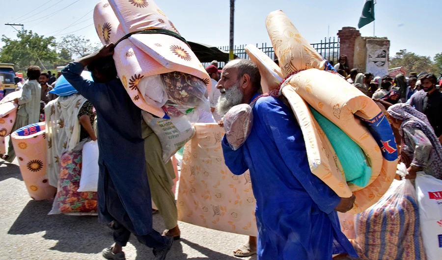 Victims of heavy flooding from monsoon rains receive relief aid provided by the Allah-o-Akbar Tehreek political party, in Quetta, Pakistan, Sept. 11, 2022. (AP)
