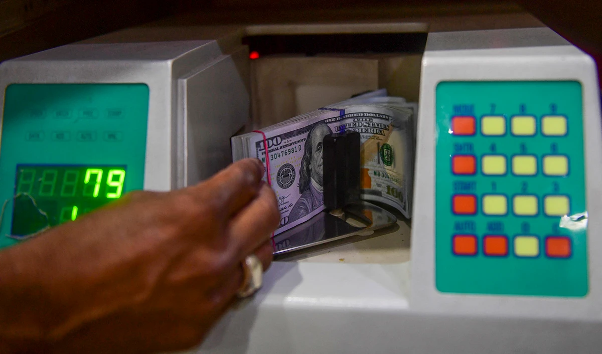 A foreign currency dealer counts US dollars at a shop in Karachi, Pakistan, on May 19, 2022. (AFP/File)