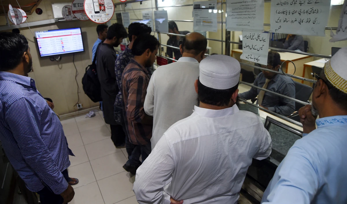 In this picture taken on July 22, 2019, customers exchange foreign currency at a money changer in Karachi. (AFP/File)