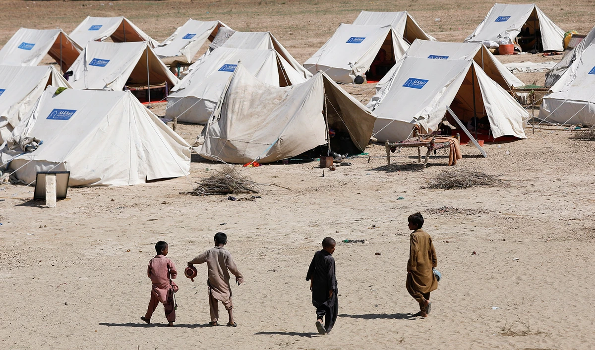 Displaced children walk outside their family tents in a camp, following rains and floods during the monsoon season in Sehwan, Pakistan, on September 16, 2022. (REUTERS)