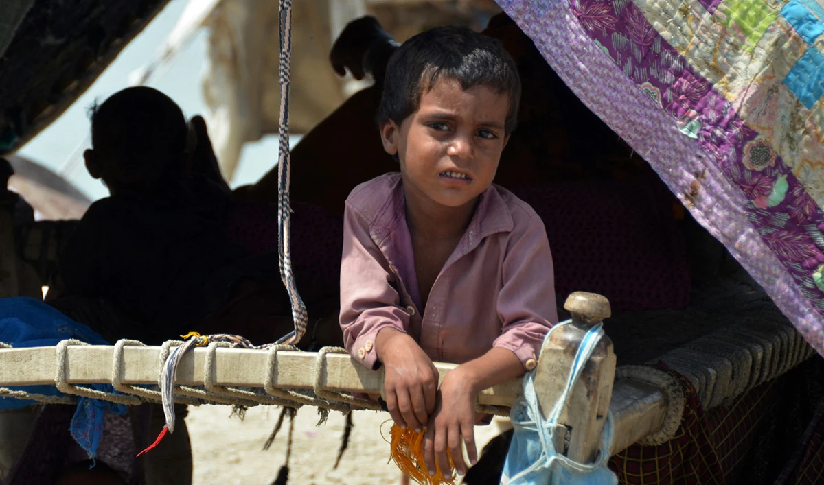 An Internally displaced flood-affected boy looks out from a makeshift tent at Dera Allah Yar town in Jaffarabad district, Balochistan province, on September 6, 2022. (AFP)