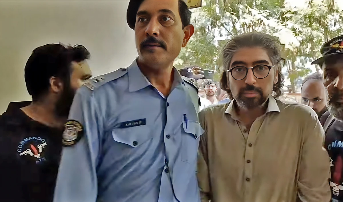 A police official escorts Shahnawaz Amir (right) to court in Islamabad, Pakistan, on September 29, 2022. (Photo courtesy: Shahid Saqlain/YouTube)