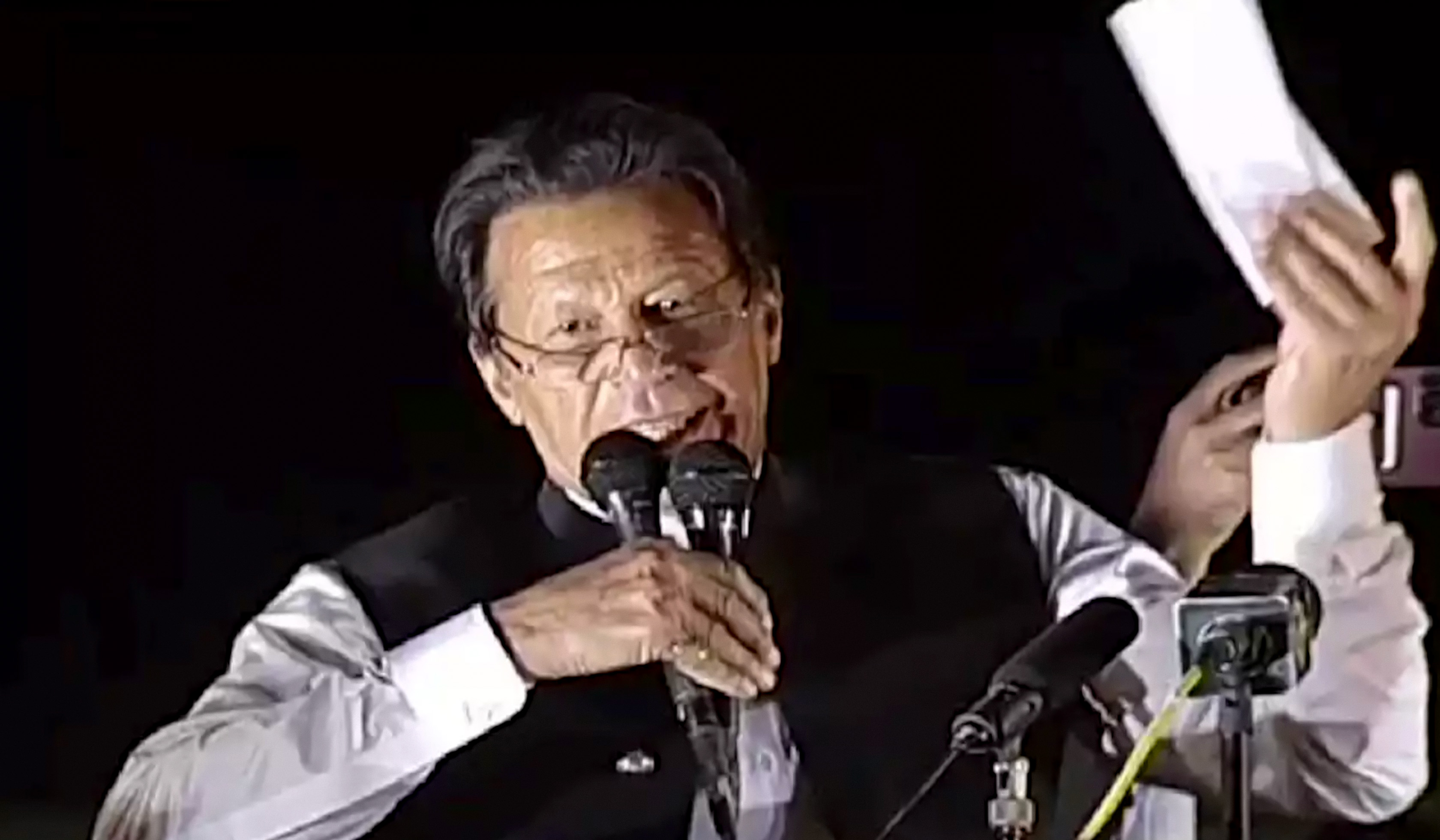 Pakistan's former prime minister Imran Khan holding what he says is a cipher which is a proof of a "foreign conspiracy" to oust him, during a political rally in Islamabad on March 30, 2022. (Photo courtesy: social media)