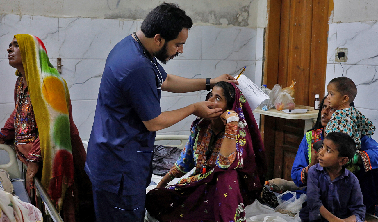 Naveed Ahmed, 30, a doctor, gives medical assistance to flood-affected girl Hameeda, 15, suffering from malaria at Sayed Abdullah Shah Institute of Medical Sciences in Sehwan, Pakistan on September 29, 2022. (REUTERS)