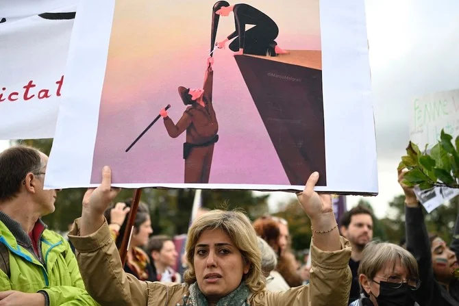 A protester holds a placard during a demonstration in support of Kurdish Iranian woman Mahsa Amini during a protest on October 3, 2022 in Nantes, western France, following her death in Iran. (AFP)