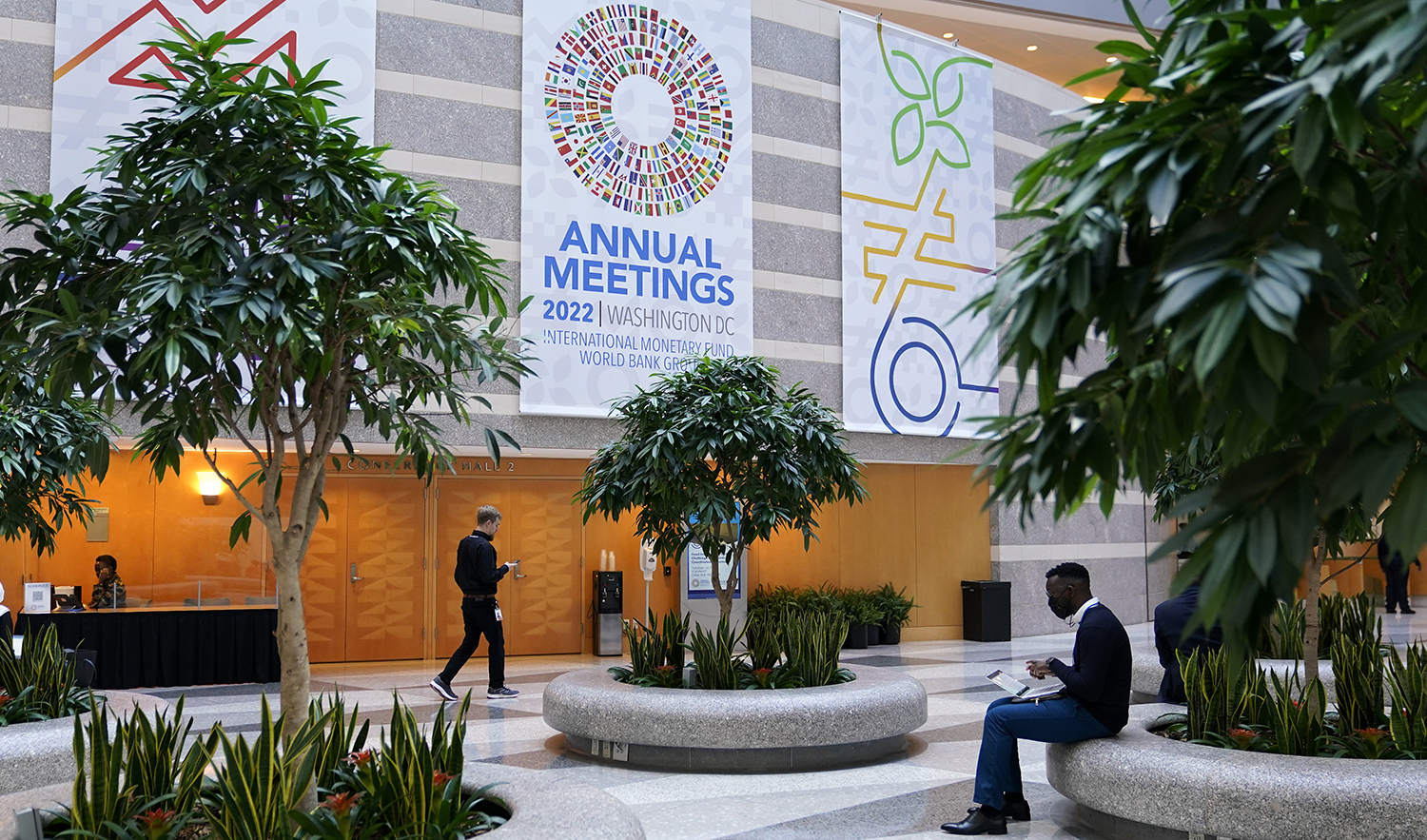 Attendees gather inside an atrium at the 2022 Annual Meetings of the International Monetary Fund and the World Bank Group, Monday, Oct. 10, 2022, in Washington. (AP)