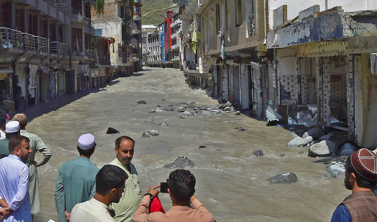 Local residents watch flood waters flowing through an area after heavy rains in Bahrain town of Swat valley in Khyber Pakhtunkhwa province on August 31, 2022. (AFP/File)