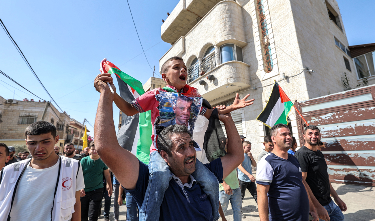Ahmed, son of Mujahid Dawoud, a Palestinian who died after being critically wounded the previous day during clashes with Israeli forces in the village of Qarawat Bani Hassan, chants slogans during the funeral in the village of Haris in the occupied West Bank on October 16, 2022. (AFP)